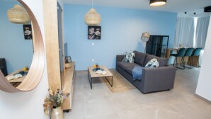 Una sala de estar moderna con sofá, mesa de centro y un espejo grande.