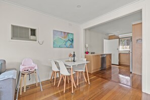 A modern kitchen with wooden cabinets, a stainless steel dishwasher, and a white countertop. - StayAU 2BRM Beach Family House Hampton (Hampton)