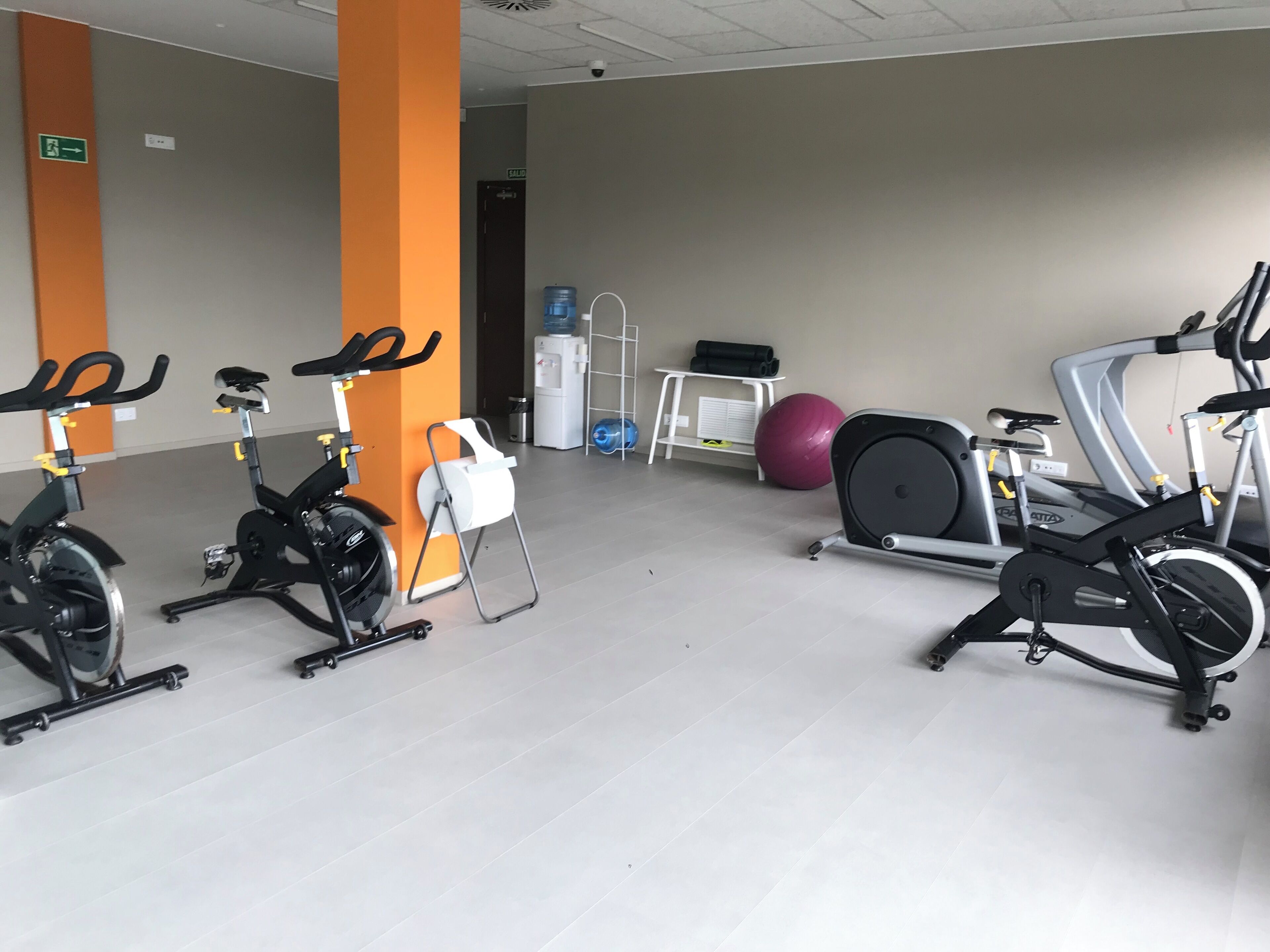 Ein Fitnessraum mit Ergometer, Rudergerät und Fitnessbällen.