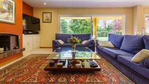 A living room with a sofa, a coffee table, a fireplace, and a television. - Country House with Garden, Near Barcelona and with Sea Views (Sant Andreu de Llavaneres)