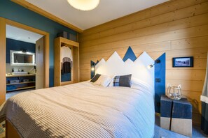 Ein Schlafzimmer mit einem Bett, einem Holzkopfteil, einem kleinen Nachttisch und einer wandmontierten Lampe.