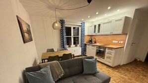 Una cucina moderna con mobili bianchi, un piano di lavoro in legno e un forno incassato.