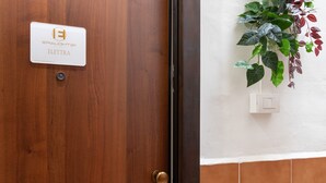 A wooden door with a sign reading 'ELECTRA EALIGHT21' and a wall-mounted light switch. - Studio Apartment 'Elettra' with Wi-Fi and Air Conditioning (Bari)