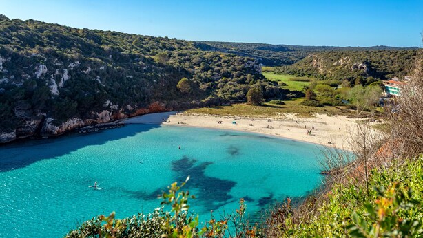 A coastal landscape with a beach, clear turquoise waters, and a hill with dense vegetation. - Villa 'Amber' with Private Pool, Wi-Fi and Air Conditioning (Cala en Porter)