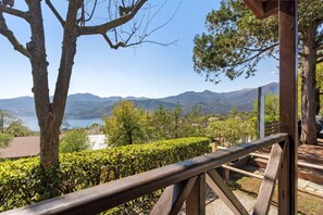 Une terrasse en bois offrant une vue sur un lac et des montagnes.