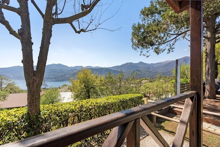 A wooden deck with a view of a lake and mountains.
