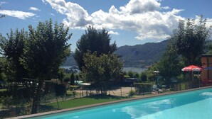 Una piscina con vistas a montañas y un lago.