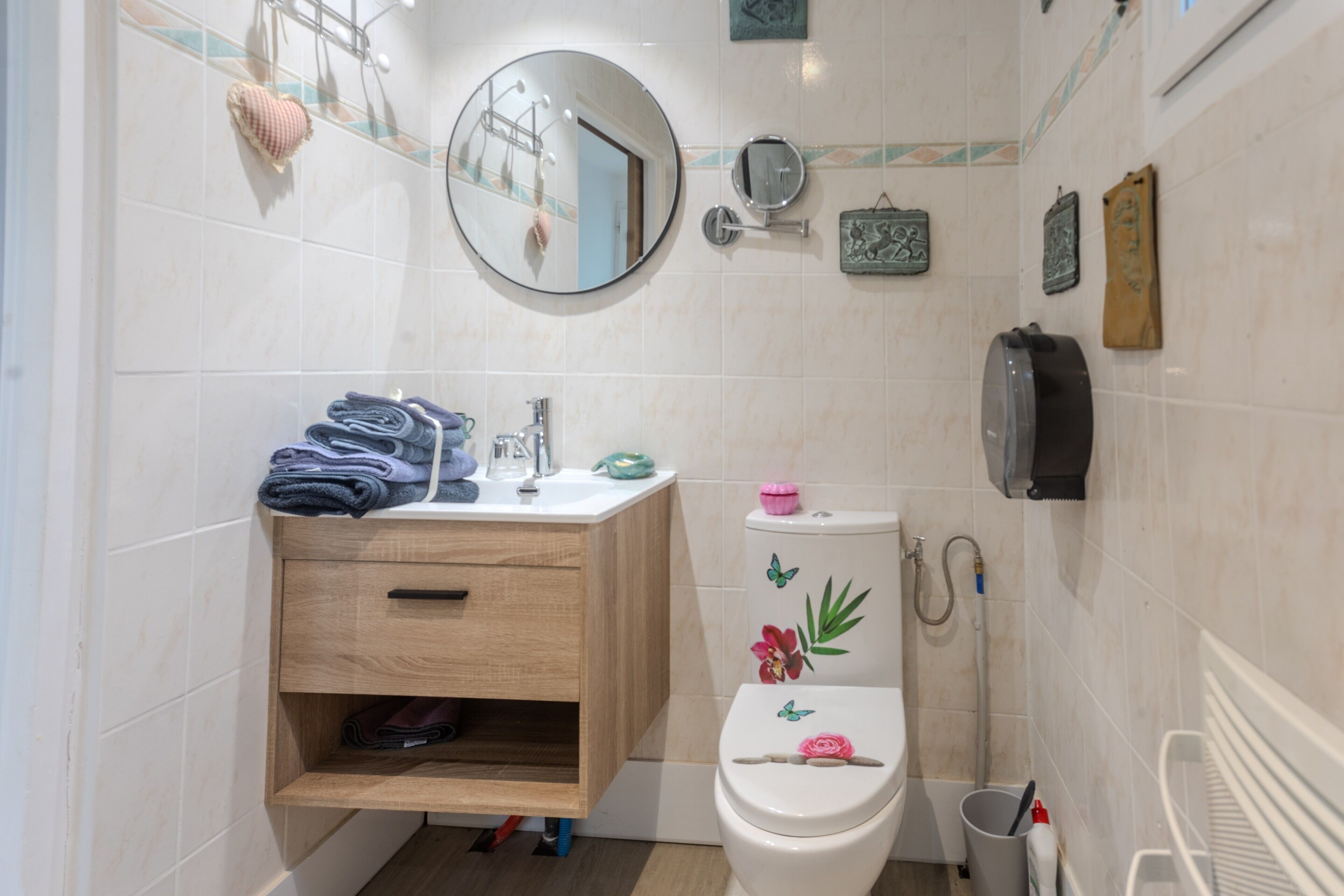 Une salle de bain équipée d’un WC, d’un lavabo, d’un miroir et d’un porte-serviettes.