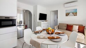 A modern kitchen with white cabinets, a built-in oven, and a flat-screen TV. - Apartment 'Penthouse Paradise - Praia Da Rocha' with Sea View, Wi-Fi and Air Conditioning (Portimão)