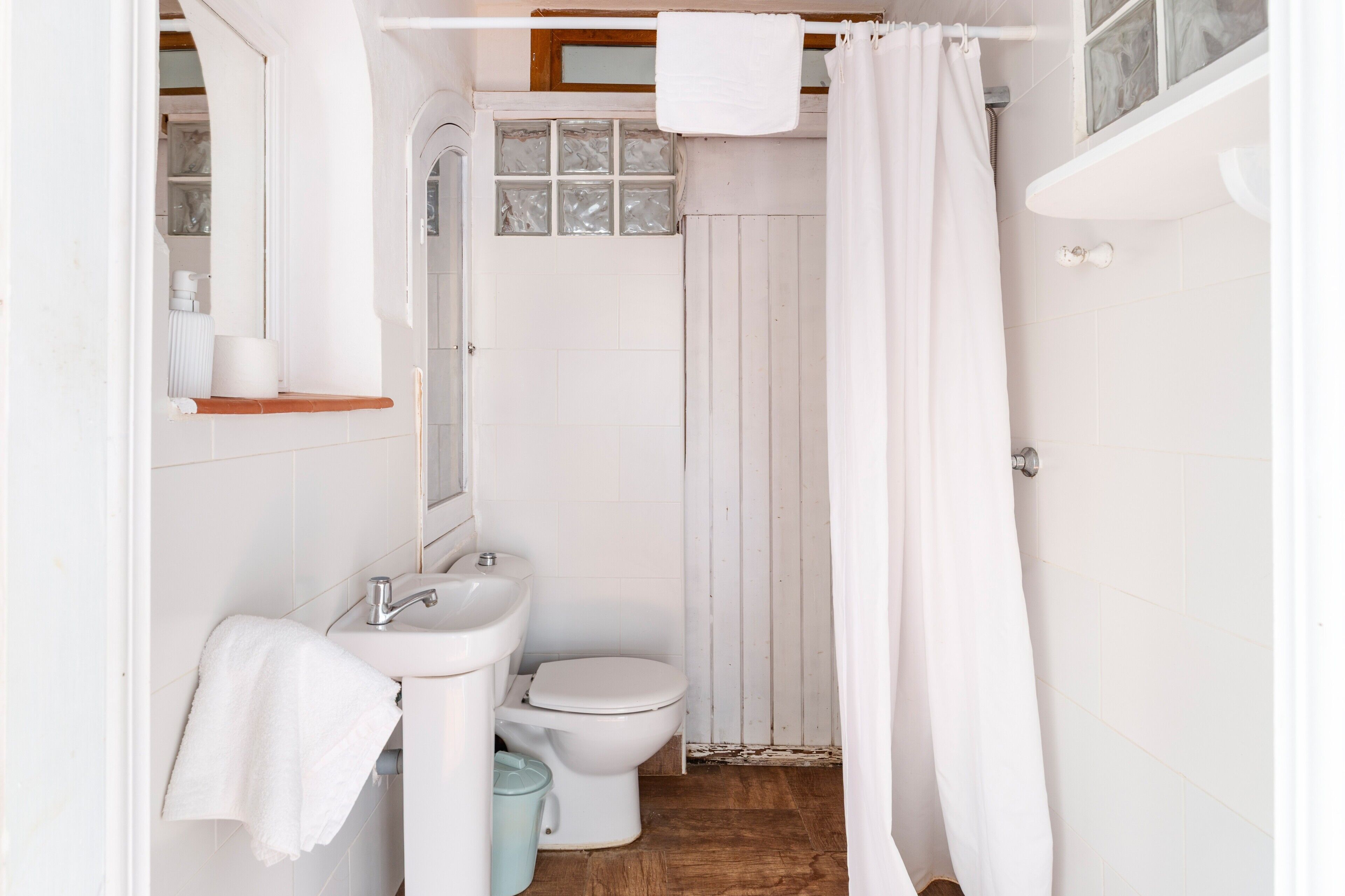 A bathroom with a toilet, sink, and shower curtain.