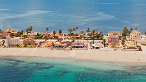 Une vue aérienne d’une ville côtière, avec ses bâtiments, sa plage et la mer.