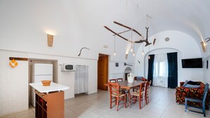 A modern kitchen with a dining area, a built-in oven, and a dining table with chairs.