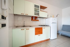 A kitchen with a sink, stove, and cabinets.