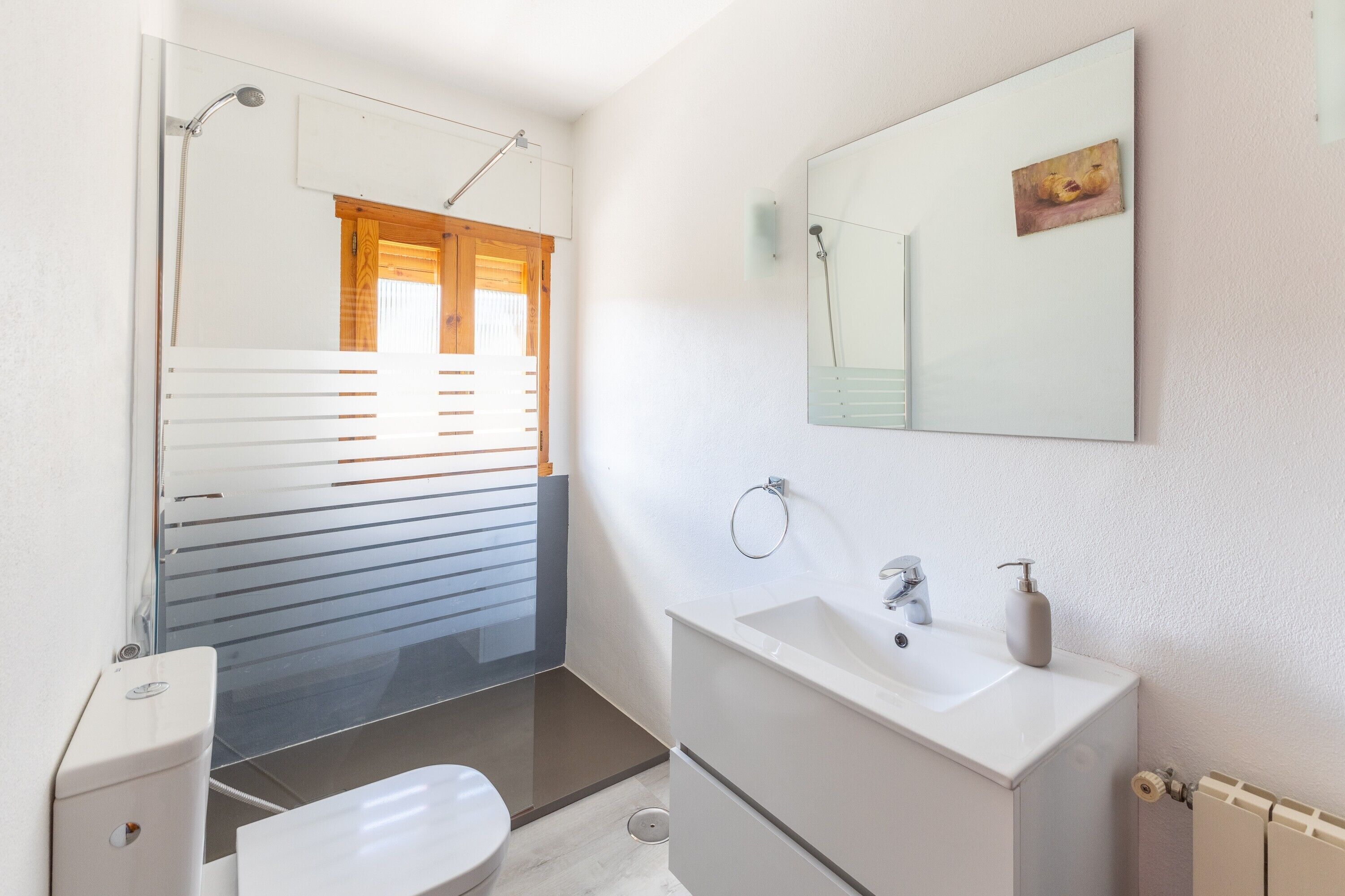 Un baño moderno con inodoro, lavamanos y ducha.