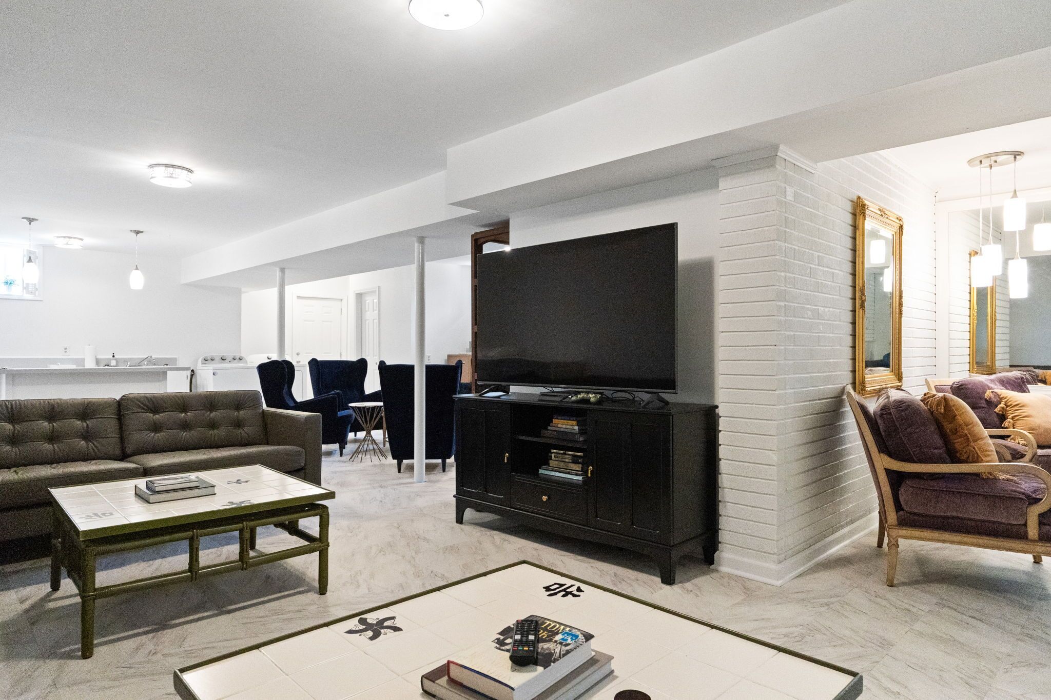 Una sala de estar moderna con un sofá modular, una mesa de centro, un televisor sobre un soporte negro y una chimenea.
