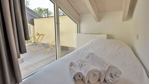 A hotel room with a bed, a window, and a view of the outside.