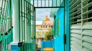 A staircase with blue walls and yellow steps leading to a building with a golden dome.
