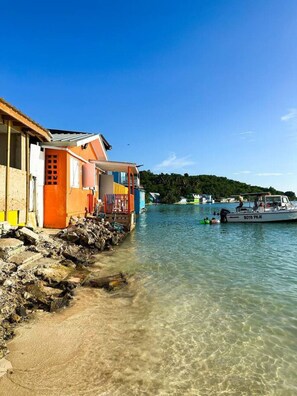 A coastal building with a clear view of the water and a boat named "BOTA PEJE" in the background. - Centrally located , Family and Pet Friendly. (Cabo Rojo)