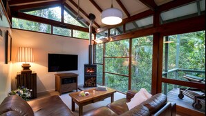 Ein geräumiges Wohnzimmer mit einer großen Couch, einem Holztisch, einem Kamin und einem Fernseher.