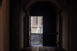 A corridor leading to a staircase with a stone wall and a metal railing. - Historic Suite w/Balcony & Stunning Views in Perugia (Perugia)