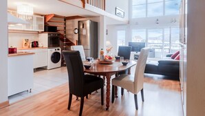 Une cuisine moderne avec un coin repas, un escalier et une vue sur la ville.