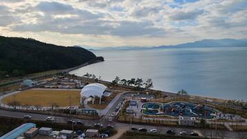 A coastal area with a parking lot, a dome structure, and a playground.