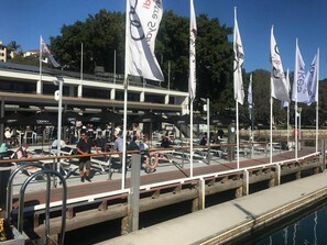 A marina with multiple white flags, a dock with seating, and a pool. - Modern, Private Luxury Apartment - Harbourside (Darlinghurst)