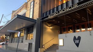 A modern building with a sign for Bistro Moncur.