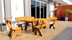 An outdoor patio with wooden benches and a trash can. - Davinci Pool Villa (Pattaya)