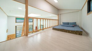 Una habitación amplia con una cama grande, piso de madera y un balcón con vistas.