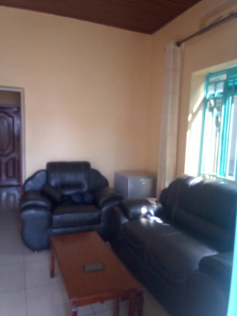 A living room with a sofa, a coffee table, and a television.