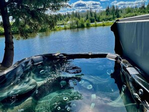 A hot tub with a clear view of a lake and surrounding trees. - Brigham Riverside Manor (Fairbanks)