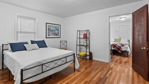 A bedroom with a bed, a shelf with items, a door, and a window. - Cute ranch house -quiet & safe -3 BR  1 Bath (Imperial)