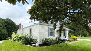 A single-story house with a front porch, surrounded by a well-maintained lawn and various plants. - Cute ranch house -quiet & safe -3 BR  1 Bath (Imperial)