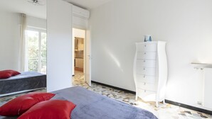 Une chambre à coucher avec un lit, une commode et un miroir.
