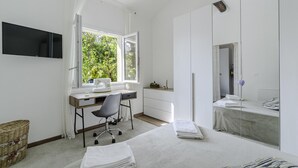 Een moderne slaapkamer met een bureau, stoel en een grote spiegel.