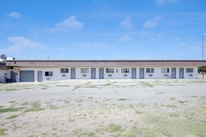 A motel with a row of rooms, each with a door number and a window.
