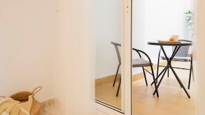 A room with a glass door leading to a dining area with a table and chairs. - Beautiful apartment on the beach (Torrevieja)