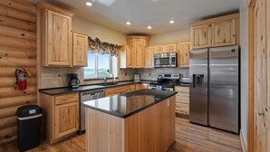 Una cocina moderna con armarios de madera, electrodomésticos de acero inoxidable y una isla grande.