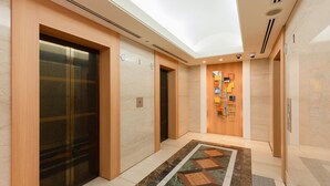 A modern elevator area with glass doors, a patterned floor, and a wall-mounted information board. - The OneFive Osaka Namba Dotonbori (Osaka)