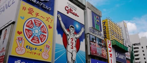 A building with multiple advertisements, including a prominent 'Glico' sign and a 'CHINTAI' sign.