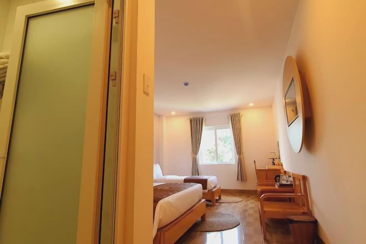 Quarto de hotel com cama, escrivaninha e cadeira.