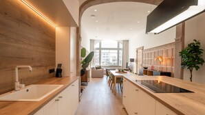 A modern kitchen with a central island, wooden cabinetry, and a large window providing natural light.