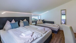 Une chambre d’hôtel moderne avec deux lits, un grand miroir et une vue sur l’extérieur.