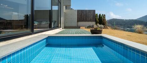 A modern outdoor swimming pool with a clear view of the surrounding landscape.