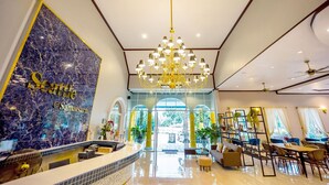 A hotel lobby with a marble reception desk, a chandelier, seating area, and large windows. - Seattle Samaesarn Resort (Sattahip)