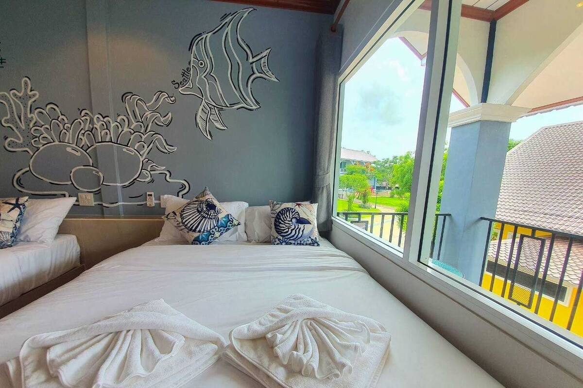 Una habitación de hotel con una cama grande, decoración en la pared y vistas al exterior.