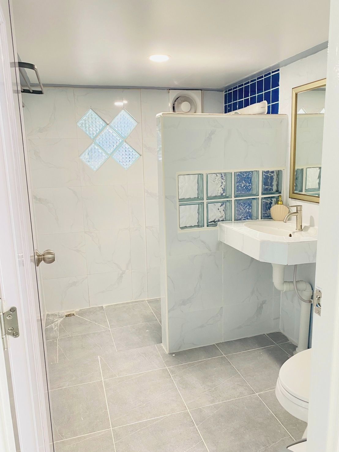 A bathroom with a white sink, a mirror, and a shower area.