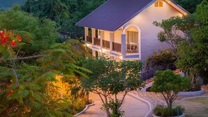 A modern house with a large balcony, surrounded by lush greenery and a winding pathway. - Seattle Samaesarn Resort (Sattahip)
