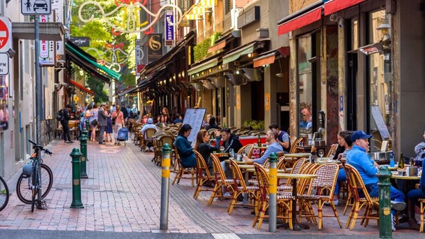 A street lined with outdoor cafes, wicker chairs, and tables. - Art Deco Retreat - Hot Tub|Parking (Collingwood)